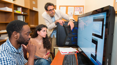 Physics students working with professor